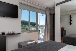 アテネにあるAthens City Center Apartmentのベッドルーム(大きな窓、テレビ付)