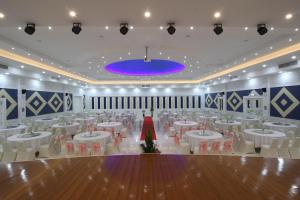 un gran salón de banquetes con mesas y sillas blancas en Nonghan Grand Hotel and Resort en Amphoe Nong Han