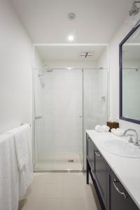 a bathroom with a shower, sink, and mirror at The Provincial Boutique Hotel in Ballarat
