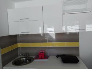 a kitchen with a sink and white cabinets at pokój blisko morza in Kołobrzeg +3 photos
