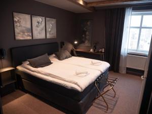 - une chambre avec un grand lit et des draps blancs dans l'établissement Hotell Gamla Staden, à Kalix