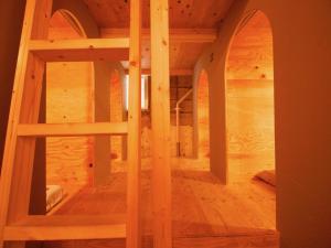 Ishigaki Guesthouse HIVE في جزيرة إيشيغاكي: غرفة خشبية كبيرة مع سرير في غرفة