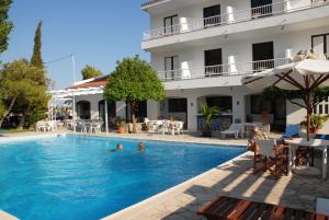 a swimming pool in front of a hotel at Apollon Resort in Pythagoreio