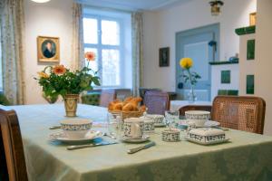 einen Tisch mit Teller und Tassen und einen Korb Brot in der Unterkunft Fischerhaus in Salem