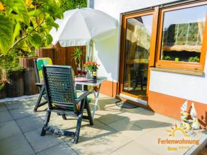 a chair sitting in front of a table with an umbrella at Ferienwohnung Ilona in Zweibrücken