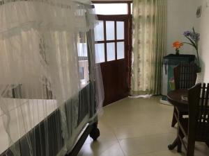 a room with a bed with curtains and a window at Galle Fantacy in Unawatuna