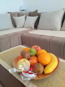 uma taça de fruta numa mesa em frente a um sofá em Apartment Laća em Vrnjačka Banja