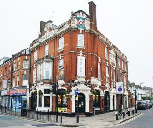 um grande edifício de tijolos vermelhos numa rua da cidade em Beaconsfield Hotel em Londres