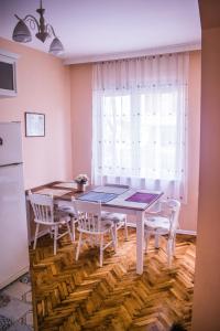 ein Esszimmer mit einem Tisch, Stühlen und einem Fenster in der Unterkunft Two Bedroom Apartment Downtown Ivanovi in Warna