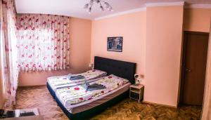 a bedroom with a bed in a room with pink walls at Two Bedroom Apartment Downtown Ivanovi in Varna City
