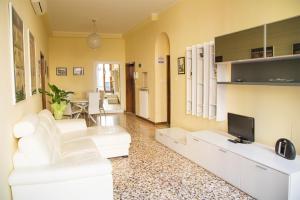 sala de estar con muebles blancos y TV en Ca' Geremia Apartment, en Venecia