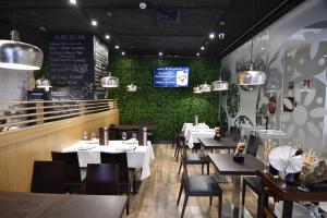 restauracja ze stołami i krzesłami oraz telewizorem na ścianie w obiekcie DWO Urban Granada w Grenadzie