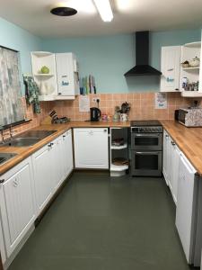 a kitchen with white cabinets and a sink at Loch Ness Backpackers Lodge in Drumnadrochit