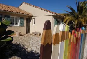 une clôture avec une planche de surf à côté d'une maison dans l'établissement La Maison de Peggy, à Garons