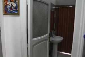une porte menant à une salle de bains avec lavabo. dans l'établissement Basic 8 Bed Mixed Dorm (share Bathroom), à Naples