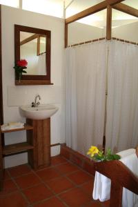 a bathroom with a sink and a shower with a mirror at Statia Lodge in Oranjestad +13 photos