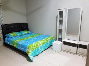 a bedroom with a bed and a dresser and a mirror at Jeish's Cottage, Pasir Gudang in Pasir Gudang