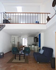 sala de estar con sofá azul y 2 sillas en Quinta dos Álamos Agroturismo en Golegã