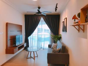 a living room with a ceiling fan and a chair and a television at Mykey The Wave A-23-15 Melaka City in Melaka