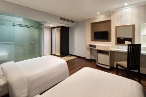 a bedroom with a bed and a desk and a television at Golden Boutique Hotel Kemayoran in Jakarta
