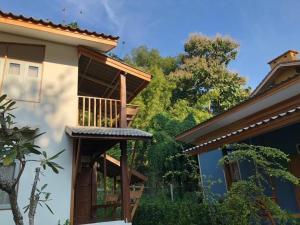 a house with a balcony on the side of it at Paiyannoi Guesthome in Chiang Mai