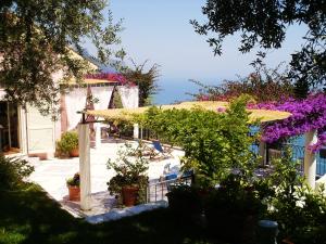 un patio con ombrellone e alcune piante e fiori di Suite I Limoni a Ravello