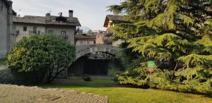 un edificio antiguo con un arco en un patio en Maison Buthier, en Aosta