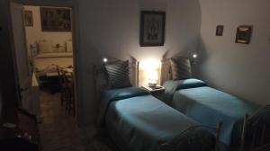 バーリにあるVilla Longo de Bellisのブルーシーツ付きの客室内のベッド2台