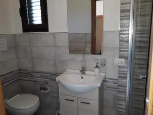 a bathroom with a white sink and a toilet at Casuzza cala pisana in Lampedusa