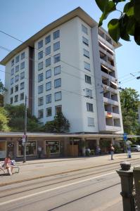 un edificio blanco alto en la esquina de una calle en PABS Résidences - Weinbergstrasse 68 (5MR), en Zúrich