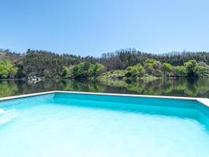 a large pool of water in front of a lake at Traditional Mansion in Treixedo with Swimming Pool in Treixedo