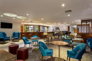 un restaurante con mesas y sillas azules y un bar en Bridgewood Manor Hotel & Spa, en Chatham