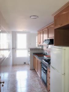 a kitchen with wooden cabinets and a white refrigerator at Avenida de Daniel Gil 72 - 2º - 7ª in Ontinyent