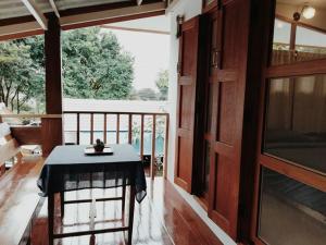 a room with a table and a balcony at Paiyannoi Guesthome in Chiang Mai