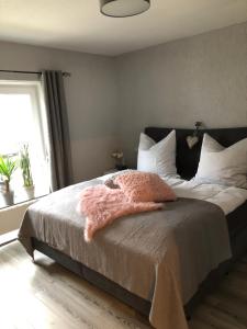 a bedroom with a bed with a pink blanket on it at Heimatliebe Fewo bei Stralsund in Steinhagen