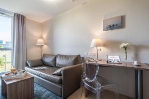 a living room with a couch and a desk at Appart’City Confort Vannes in Vannes