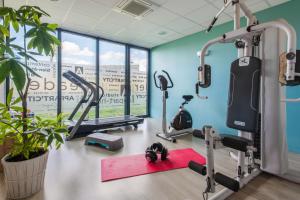 een fitnessruimte met loopbanden en hometrainers bij Appart’City Confort Vannes in Vannes