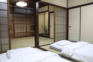 a room with two beds in front of a mirror at Guesthouse Omihachiman in Omihachiman
