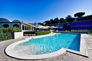 a swimming pool with blue water in front of a building at All Time Relais & Sport Hotel in Rome