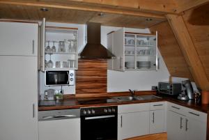 a kitchen with white cabinets and a stove top oven at Ferienhäuser Finiki in Purbach am Neusiedlersee