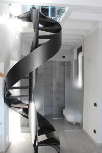 a black spiral staircase in a bathroom with a shower at Larian Chalet in Moltrasio