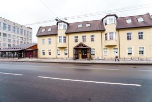 ein großes gelbes Gebäude an der Straßenseite in der Unterkunft Hotel Ekaterinhof in Sankt Petersburg