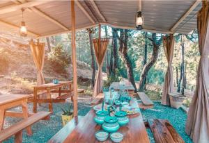 a table in a tent with blue dishes on it at Nayalap - Rural Himalayan Glamping in Shitlakhet