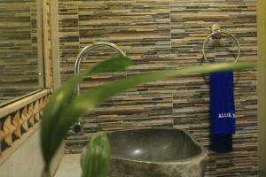 La salle de bains est pourvue d'un lavabo et d'une serviette bleue. dans l'établissement Alur Beach Homestay, à Amed