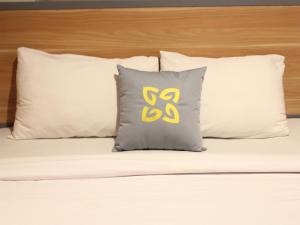a pillow with thess on it sitting on a bed at Ghurfati Hotel Mangga Besar in Jakarta