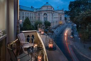 uma varanda com mesas e cadeiras e um edifício em BANKHOTEL em Lviv