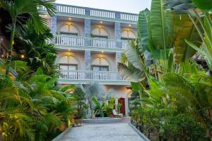 un edificio con molte piante di fronte di Reveal Courtyard in Reveal Angkor a Siem Reap