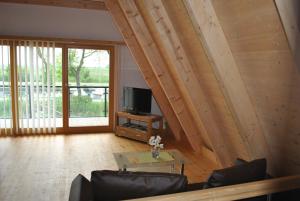 ein Wohnzimmer mit einem Sofa und einem TV in der Unterkunft Ferienhäuser Finiki in Purbach am Neusiedlersee