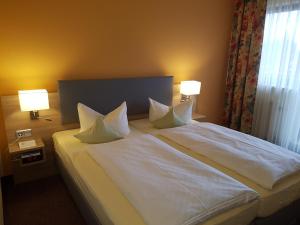 Postel nebo postele na pokoji v ubytování Hotel Merian Rothenburg
