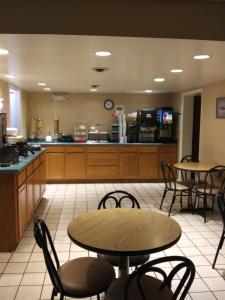 a restaurant with tables and chairs and a kitchen at Bestway Inn - Madison in Madison